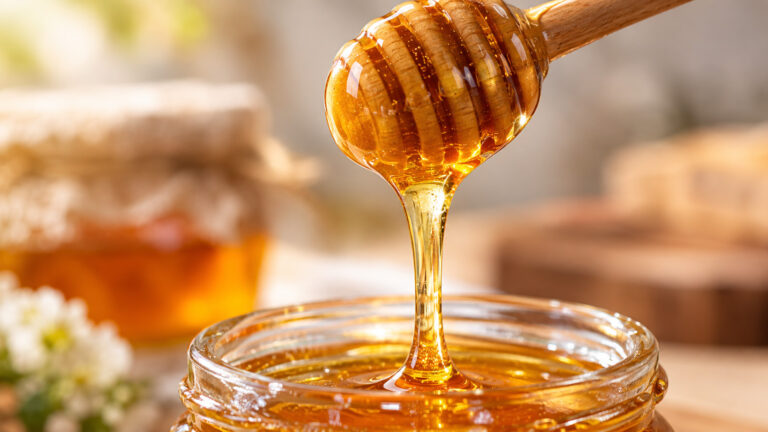 There is honey dripping down from the honey stick